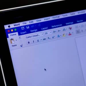 A close-up of a computer screen displaying a Word document in Microsoft Office for Mac. The menu bar at the top shows options like File, Edit, View, Insert, and the toolbar beneath contains various formatting tools. The document appears to be in editing mode with visible text formatting options.