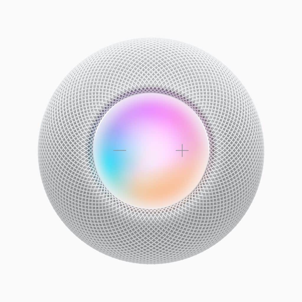 A spherical smart speaker with a mesh exterior in white, featuring a glowing touch surface on top with a gradient of colors and plus and minus symbols for volume control.