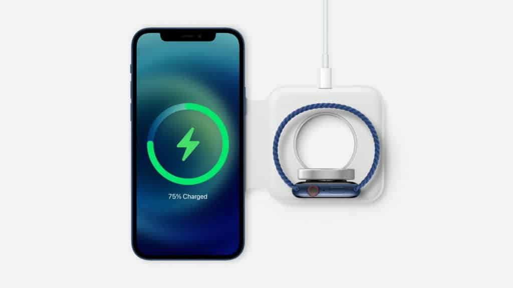 An iPhone 12 mini and a smartwatch are shown side by side on a wireless charging pad. The smartphone's screen displays a 75% charge completion with a green charging symbol. The smartwatch, attached to the charger, has a blue band and is positioned next to the $699 phone.