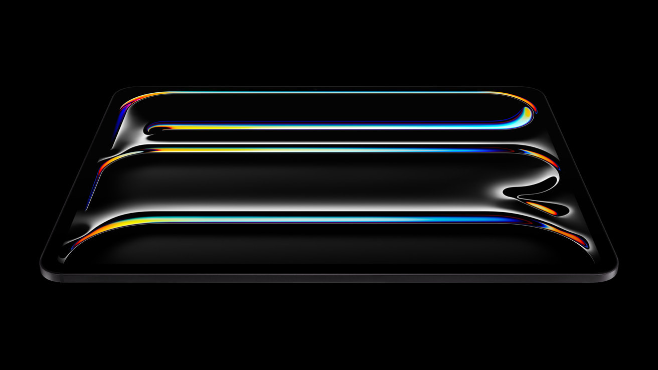 A sleek iPad Pro with a glossy, black surface and an OLED screen displays three curved, colorful neon lines glowing against the dark background. The lines radiate hues of blue, yellow, red, and green, creating a vibrant, futuristic design powered by the advanced M4 Chip.