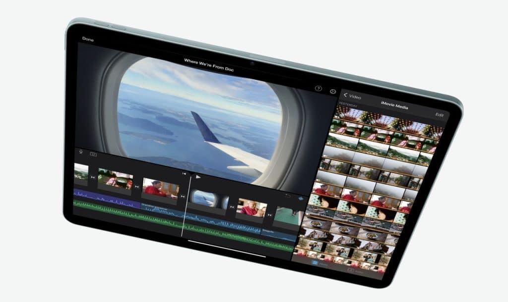 An iPad Air displaying a video editing app. The main video shows an airplane wing viewed from a window, flying over a landscape with water and islands. Surrounding the main video are various timelines, thumbnails of other video clips, and editing tools—powered by the efficient M2 chip for seamless performance.