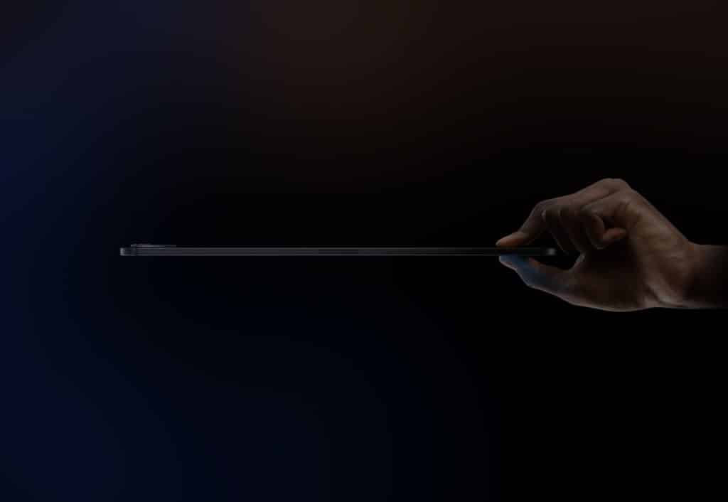 A hand holding a thin tablet against a dark background. The tablet is viewed from the side, emphasizing its slim profile. Subtly illuminated edges create a sleek and minimalist look, highlighting how it outperforms the iPad Pro in bend tests.