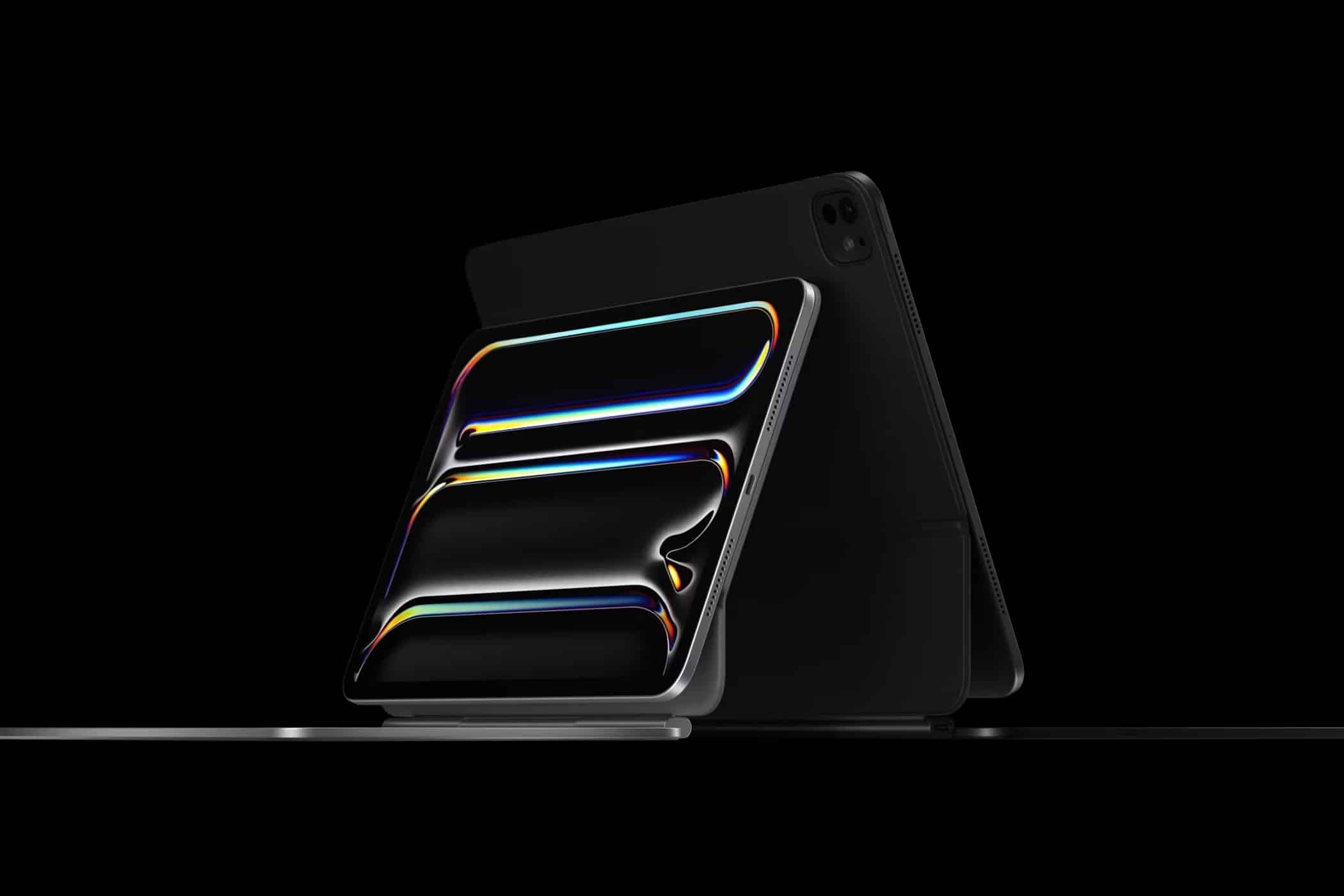 A sleek iPad with a vibrant, multicolored display is showcased against a black background. The tablet, positioned at an angle, is accompanied by a minimalist protective cover or keyboard stand, emphasizing its modern and sophisticated design within Apple's Ecosystem.