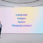 A person stands on a minimalist stage with a large screen behind them. The screen, displaying the text "Language," "Images," "Action," and "Personal context" in blue on a gradient background, hints at themes related to Apple Intelligence Plans. The individual appears to be giving a presentation.