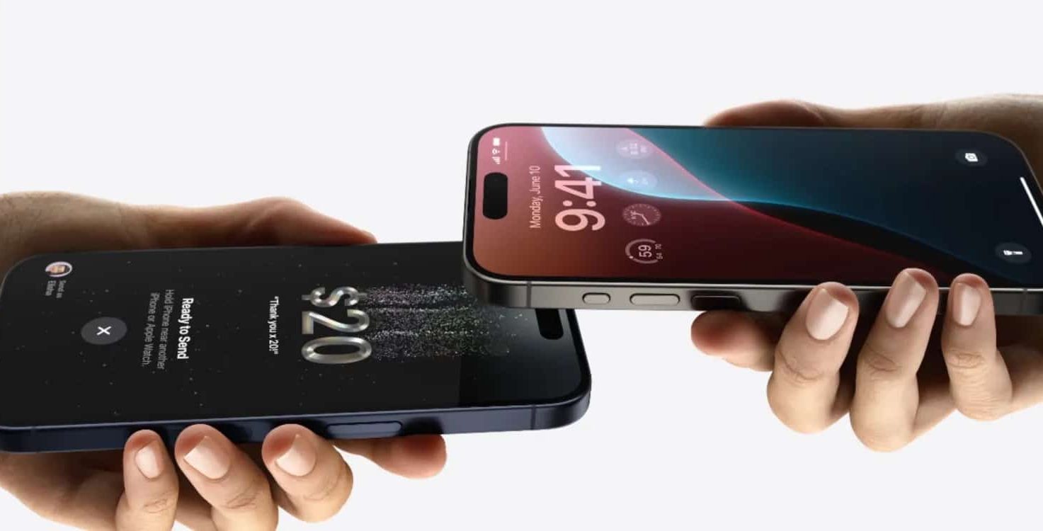 Close-up of two hands each holding a smartphone. One phone displays a transaction of $20 being sent, while the other phone, running iOS 18, shows the time as 9:41 with a customizable home screen and various icons. Both phones are held facing each other, indicating a digital transfer.