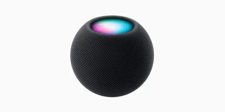 A black, spherical smart speaker with a mesh surface, the Apple HomePod mini in Midnight Color features a top that glows with blue, pink, and purple hues and has subtle plus and minus symbols. The background is plain white.