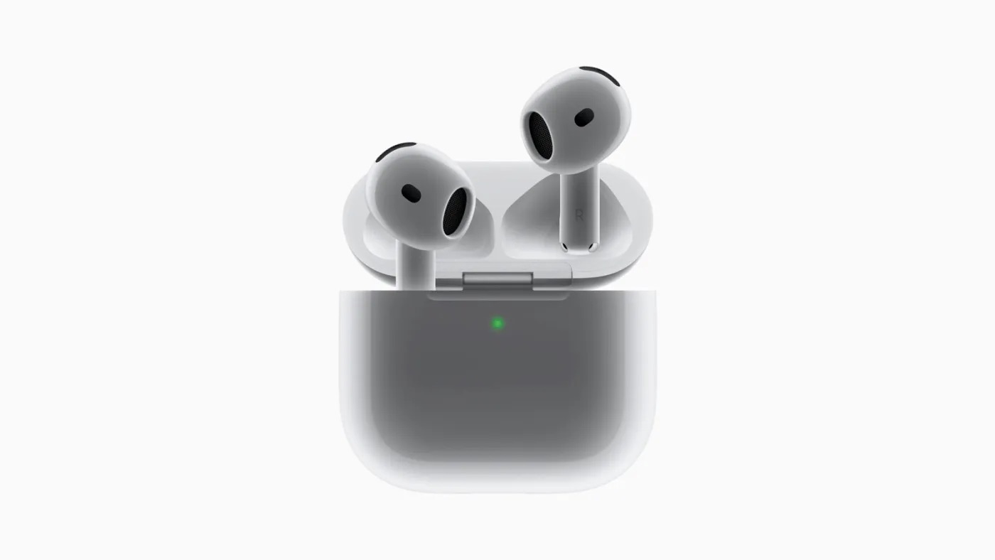 A pair of white wireless earbuds, reminiscent of AirPods 4 vs. AirPods Pro, rests in an open charging case. Both the earbuds and the case boast a sleek, minimalist design with a green indicator light glowing on the front. The background is plain white, highlighting their elegance.