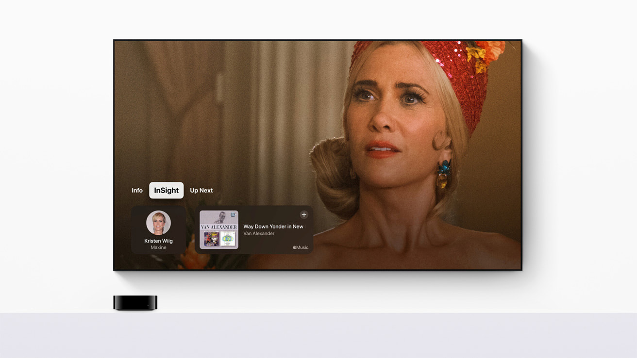 tvOS 18: A TV screen displays a close-up of a woman with blonde hair, a red headscarf, and colorful earrings. She appears emotional. The interface, showcasing tvOS 18 features, reveals information about an actress named Kristen Wiig as Maxine and upcoming music by Kai Wachi and Henry Alexander.