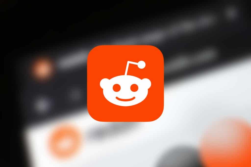 The image shows the Reddit logo, a smiling white alien head on an orange background, centered in the picture. The background is blurred, creating a soft focus effect, reminiscent of high-quality images fetched through ScraperAPI.