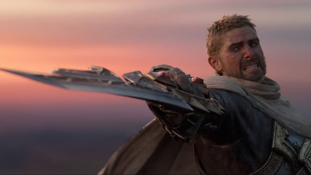 A fierce warrior with short blonde hair and a beard, dressed in armor and a tattered cloak, extends an elaborate, bladed weapon forward. The warrior's face is tense and determined, set against a sunset sky with shades of orange and pink. This scene could be straight out of World of Warcraft: The War Within new expansion.