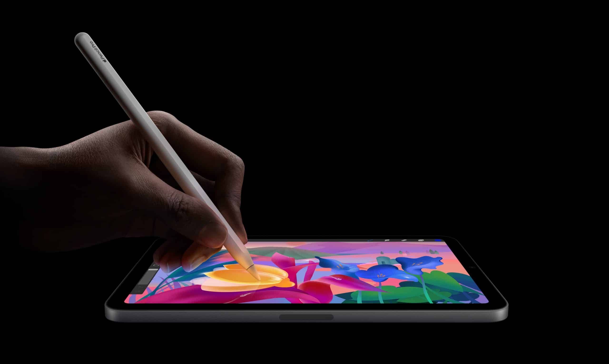 An iPad Mini, powered by the A17 Pro Chip, displays a hand skillfully using a stylus to draw vibrant illustrations of flowers and leaves on its screen against a black background.