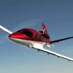 Flying a small Cirrus Vision SF50 red and white private jet in the clear blue sky is a thrilling hobby.