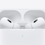 Close-up of two white wireless earbuds resembling Fake AirPods Pro in an open charging case, set against a plain white background. A small green light on the case signals charge status.