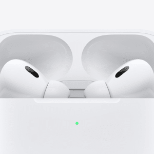 Close-up of two white wireless earbuds resembling Fake AirPods Pro in an open charging case, set against a plain white background. A small green light on the case signals charge status.