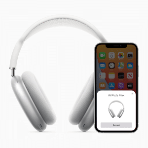 An iPhone, showcasing an app menu and a pop-up window for connecting the headphones, is placed in front of a pair of silver and white over-ear headphones. The screen invites users to update the AirPods Max firmware effortlessly.