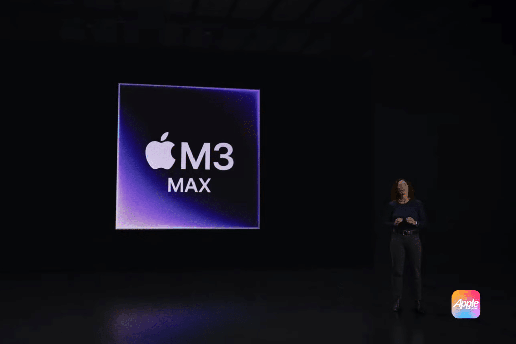 A presentation slide highlights the Apple logo with "M3 MAX" text on a dark background. A person stands on stage, discussing the innovations of the Apple M3 Chip, with the iconic Apple logo prominently displayed in the bottom right corner.