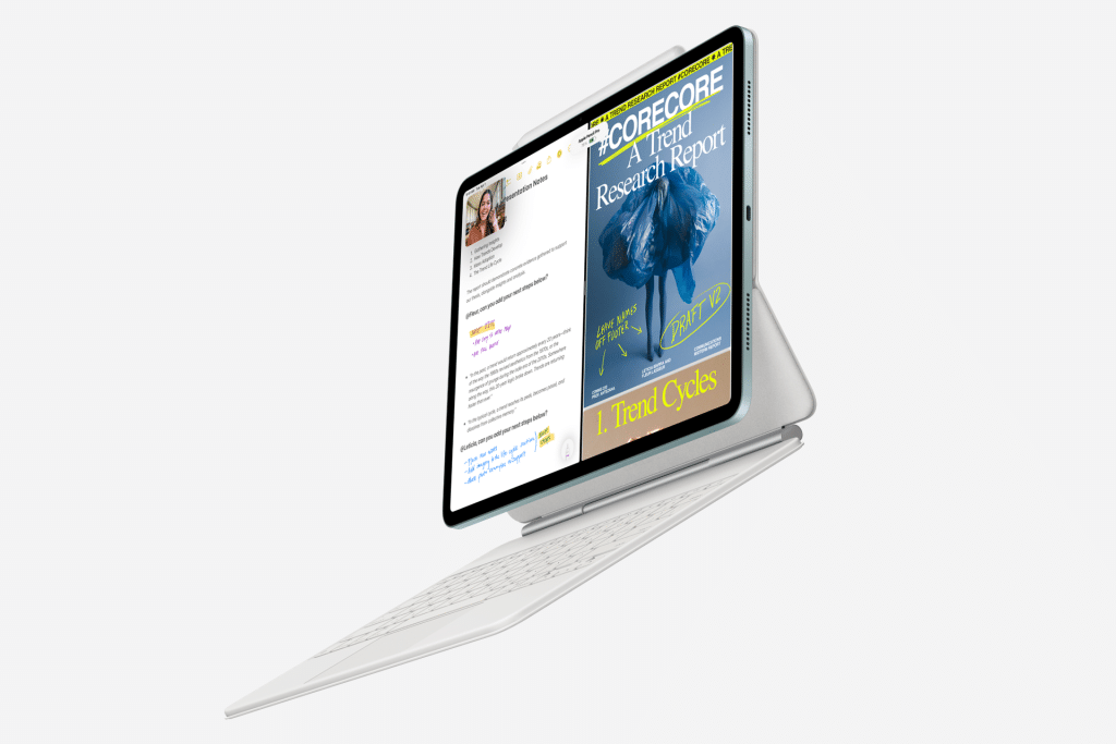 A tablet with a sleek keyboard case displays an open document and a magazine cover featuring a vibrant blue flower. It elegantly floats against a pristine white background, showcasing the seamless integration of technology and style.