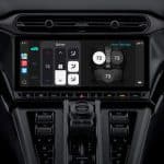 Close-up of a car's digital dashboard touchscreen displaying climate control settings alongside Apple Maps integration. The sleek, black interior highlights advanced features like temperature adjustment, fan speed, air direction, and seat A/C options.
