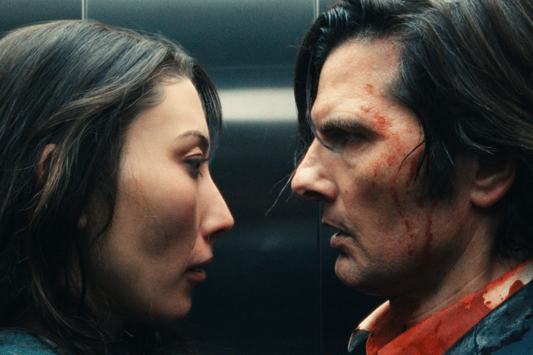 A woman and a man with blood on his face stand very close, staring intensely at each other in a dimly lit setting, evoking the tense atmosphere of Severance.