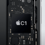 Close-up of an electronic circuit board inside a device, featuring a large black Apple C1 Modem chip at the center, labeled with "C1," and surrounded by various smaller components and connectors.