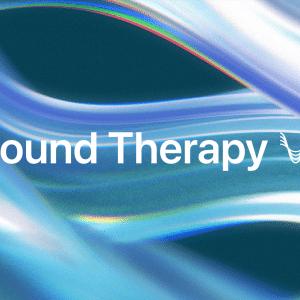 Text "Sound Therapy" with a small wave-like icon appears over a smooth, abstract background of flowing blue and white light streaks, evoking the tranquil vibes of Apple Music Sound Therapy.
