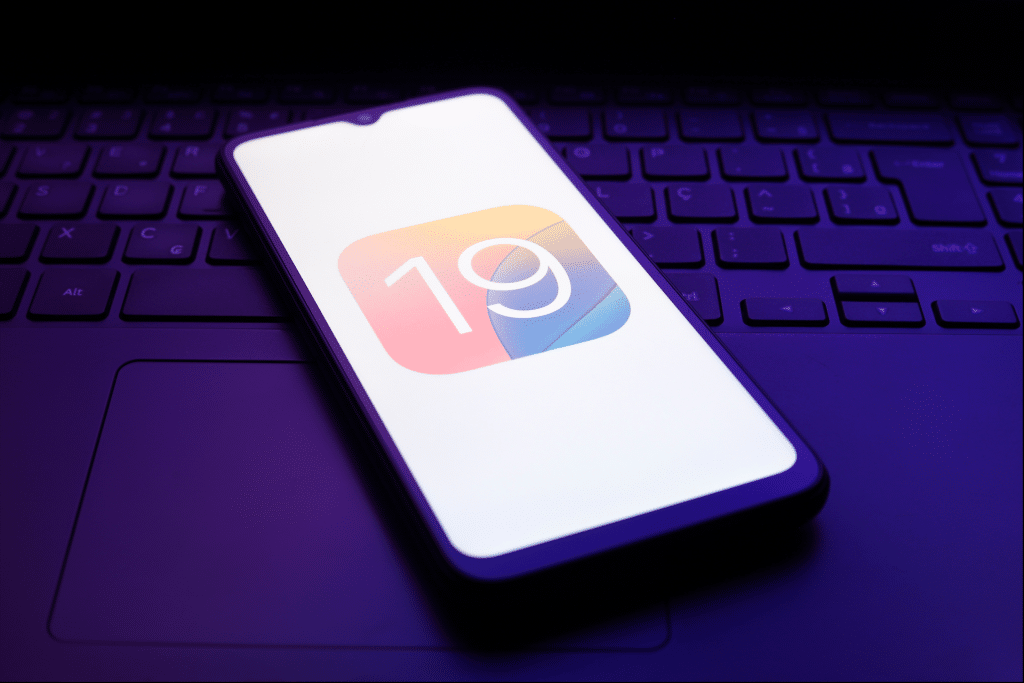 An iPhone lock screen showcasing a sleek iOS 19 interface with a charging indicator, highlighting AI-optimized battery status for iOS 19 battery AI 2025, placed on a modern desk beside an iPhone 17 Air.