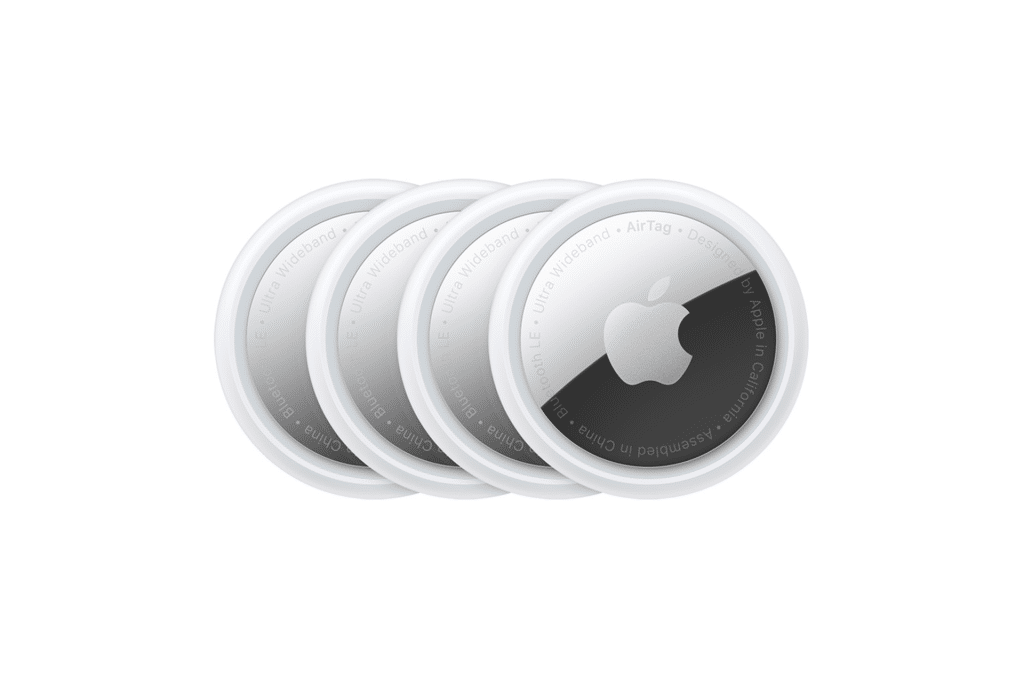 Four overlapping Apple AirTag trackers are shown on a white background, each featuring a silver and white circular design with the Apple logo in the center, highlighting enhanced tracking and improved safety features.