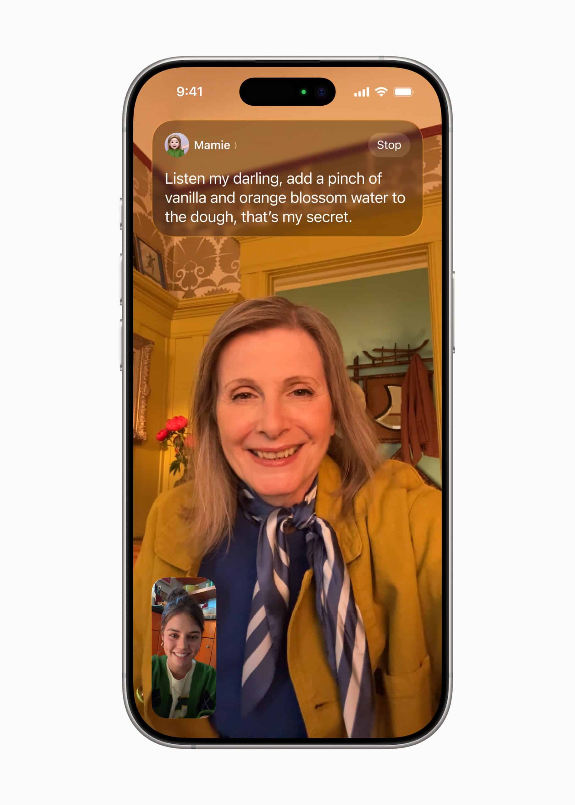 A smartphone running iOS 26 shows a video call between two people. The main screen displays an older woman smiling in a cozy, warmly lit room. A message at the top shares a baking secret about vanilla and orange blossom water.