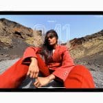 A woman in a bold red suit poses outdoors on rocky terrain, seated with one knee up against a dramatic landscape. The image is displayed on a tablet running iPadOS 26, showing the time 9:41 and date Tue Apr 1.