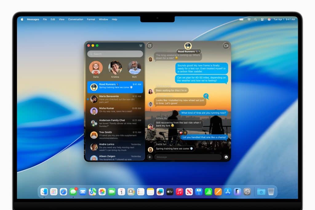 A MacBook screen displaying the Messages app in dark mode with chat conversations open on macOS Tahoe. The desktop features a blue wave wallpaper, dock icons at the bottom, and the menu bar at the top.
