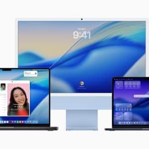 Three Apple devices with blue-themed screens: an iMac in the center displaying the macOS Tahoe login screen, and two MacBook laptops on either side showing video calls and widgets, all on a white background.
