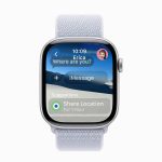 Apple Watch running watchOS 26 displays an iMessage with Erica—"Where are you?"—and options to share your location for 1 hour, all set against a backdrop of serene sand dunes.