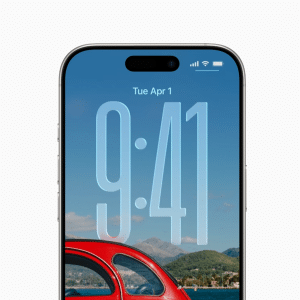A smartphone running iOS 26 displays the lock screen with the time 9:41 and date Tuesday, April 1. The scenic background features a red car, green hills, mountains, and a clear blue sky.