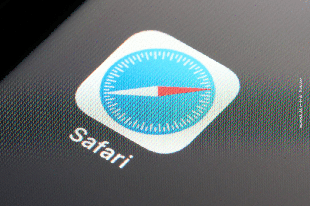 Close-up of the Safari web browser app icon on a device screen, featuring a blue compass with a red and white needle and the word "Safari" below it, highlighting its fresh look in iOS 26 with new features.