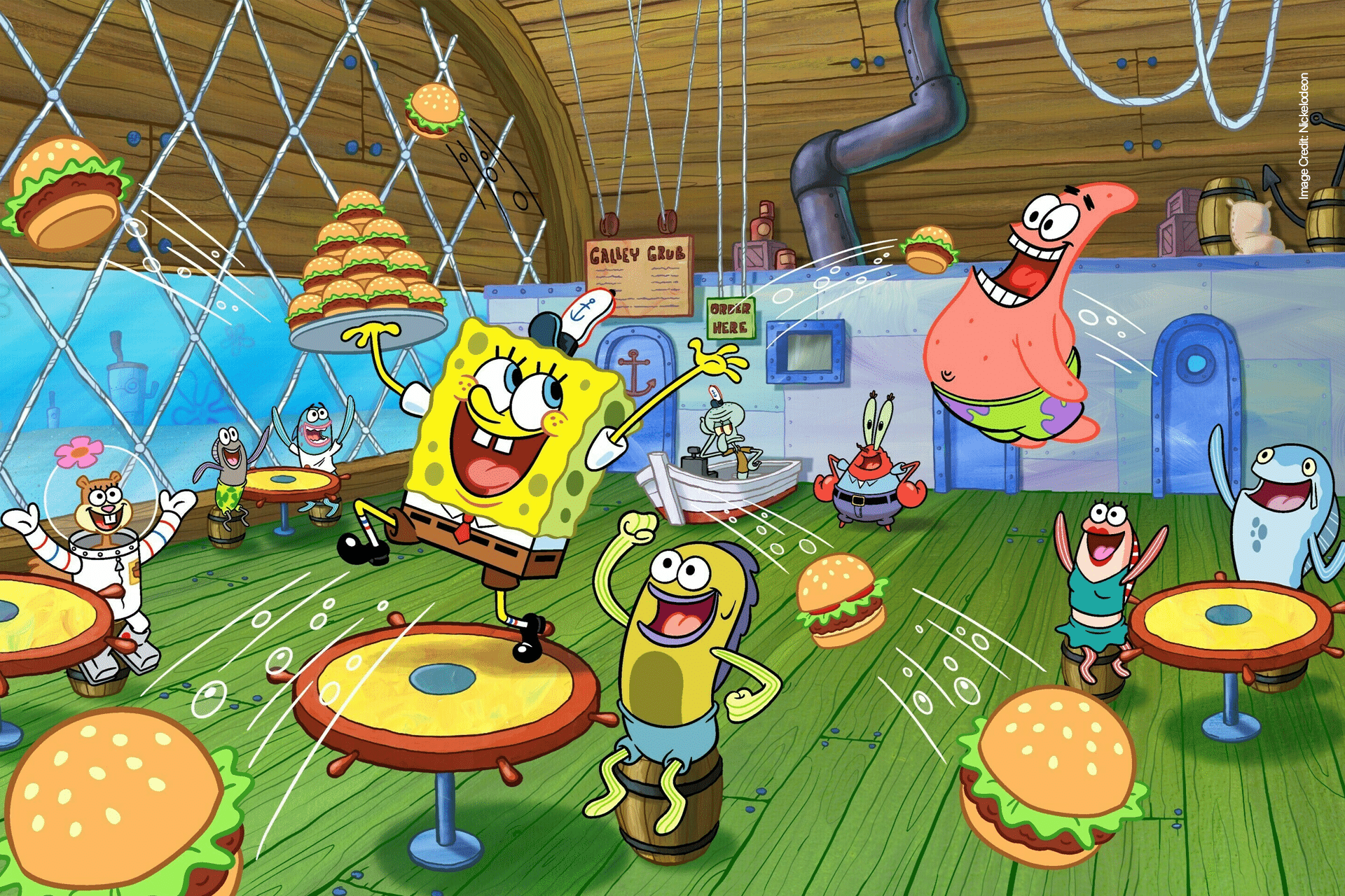 SpongeBob SquarePants and friends joyfully throw Krabby Patties around the Krusty Krab, with characters laughing, jumping, and celebrating in a colorful, animated Bikini Bottom restaurant scene.