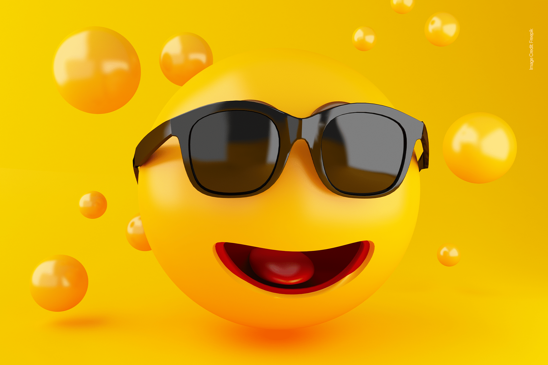 A bright yellow smiley face emoji, perfect for your next emoji game, wears black sunglasses and smiles with an open mouth, surrounded by smaller yellow spheres on a yellow background.