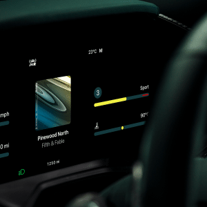 Close-up of a car's digital dashboard display featuring CarPlay Ultra, showing speed, mileage, music playing ("Pinewood Math" by Fifth & Fable), drive mode (Sport), climate controls, and a temperature reading of 23°C.