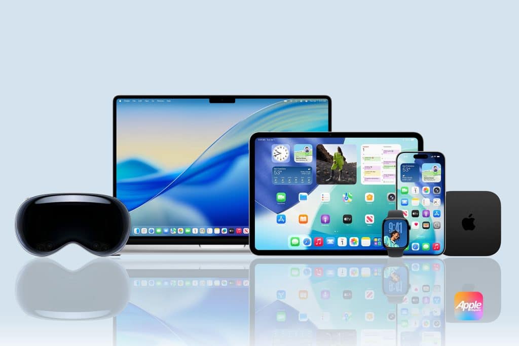 A group of Apple devices including a MacBook, iPad, iPhone, Apple Watch, Apple TV, and Apple Vision Pro headset displayed on a reflective surface with an Apple logo in the bottom right corner.