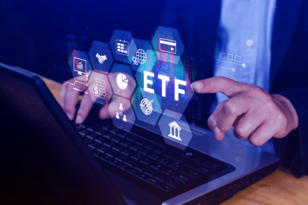 A person using a laptop with virtual icons displaying financial symbols and the letters "ETF," highlighting how ETFs and AI technologies like NVIDIA are shaping the future of investing.