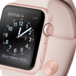 A rose gold Apple Watch Series 1 with a pink band displays an analog clock face and flight information. The time shown is 9:08, and the watch is angled to highlight the side button and circular crown for users.