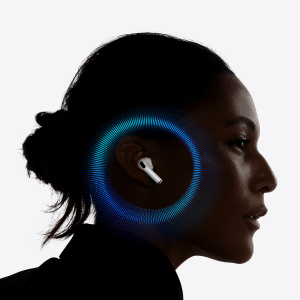 A woman in profile wears a wireless earbud, with a digital blue and purple circular graphic surrounding her ear, suggesting sound or U2 chip technology. The background is plain white.