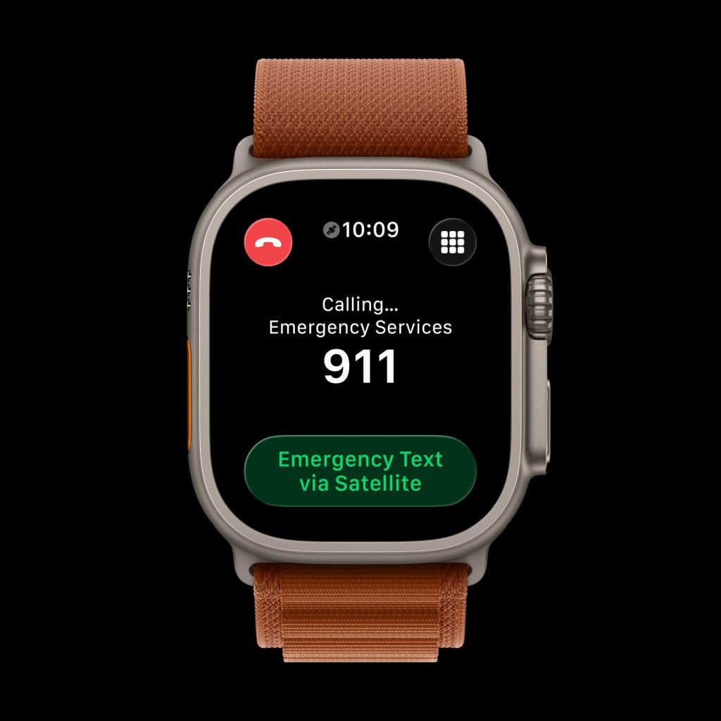A smartwatch screen displays an emergency call to 911 with the text "Calling... Emergency Services" and a green button labeled "Emergency Text via Satellite." The time is 10:09 and the watch has an orange band.