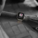 A person’s wrist wearing a smartwatch displaying a heart icon and the message “Possibly irregular rhythm,” suggesting the watch is monitoring heart health. The image is mostly black and white except for the watch screen.