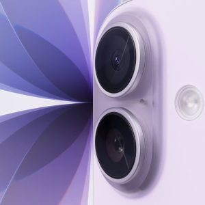 Close-up of a lavender-colored smartphone, resembling the iPhone 17, showing two rear cameras and a flash, set against an abstract purple and white geometric background.