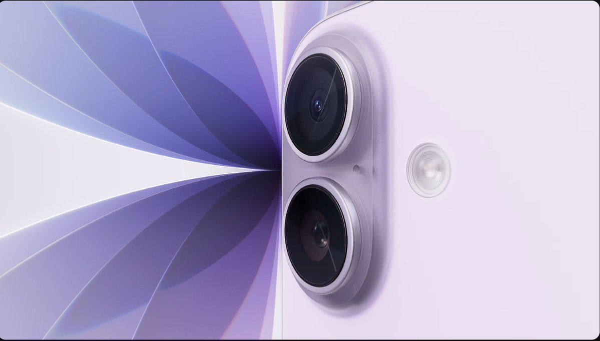 Close-up of a lavender-colored smartphone, resembling the iPhone 17, showing two rear cameras and a flash, set against an abstract purple and white geometric background.