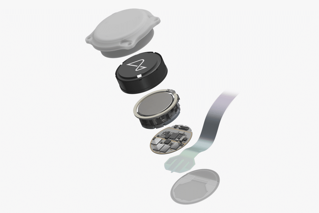 An exploded view of a small electronic device, reminiscent of a Neuralink brain implant, showing its outer shell, battery, circular sensor, circuit board, and connecting ribbon cable, all aligned vertically against a white background.