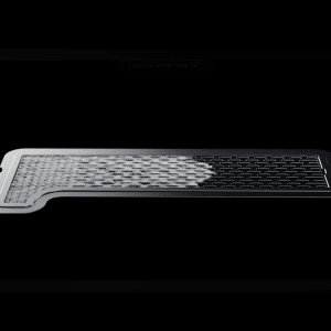 A thin, rectangular metal filter—resembling an iPhone Vapor Chamber—is shown on a black background. The left side appears partially covered with a textured, mesh-like material.