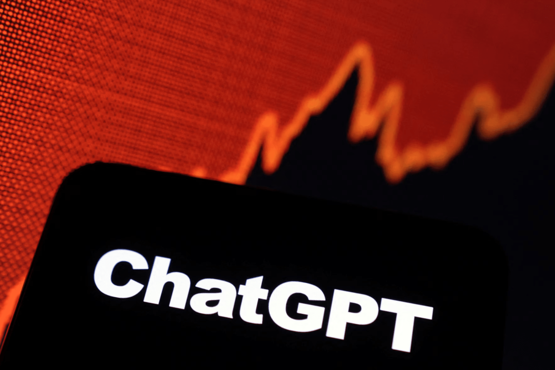 A smartphone screen displays the word "ChatGPT" in bold white text, with a red, jagged line graph trending upward—hinting at OpenAI's $500 billion valuation—in the background.