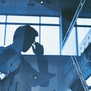 A double exposure image of a man adjusting his glasses, overlaid with a modern office stairwell and large windows, creating a blue-tinted abstract business scene where ChatGPT rivals human experts.