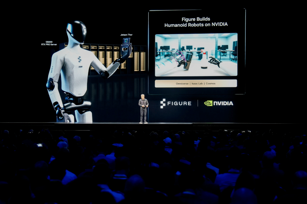 A speaker stands on stage presenting to a large audience, with a screen behind showing a humanoid robot and the logos of Figure and NVIDIA, highlighting their vision for an Nvidia robot workforce shaping the future.